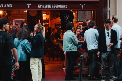 Miniature Location salle Paris 9 (Paris) - Club Cochon l'Auberge #49 Deux jeunes femmes souriantes tenant des verres, entourées de personnes dans une ambiance festive et lumineuse.