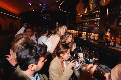 Miniature Location salle Paris 9 (Paris) - Club Cochon l'Auberge #12 Deux jeunes femmes souriantes tenant des verres, entourées de personnes dans une ambiance festive et lumineuse.