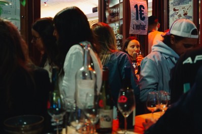 Miniature Location salle Paris 9 (Paris) - Club Cochon l'Auberge #59 Deux jeunes femmes souriantes tenant des verres, entourées de personnes dans une ambiance festive et lumineuse.