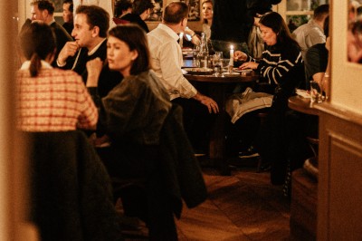 Façade d'un restaurant avec une enseigne ’Club Cochon - La Cave’, terrasse avec tables et chaises devant.