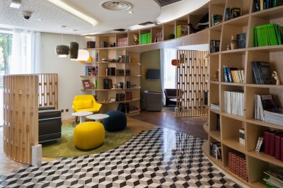 Salle de bain moderne avec baignoire, lavabo, miroir, peignoir suspendu et sol en damier noir et blanc.