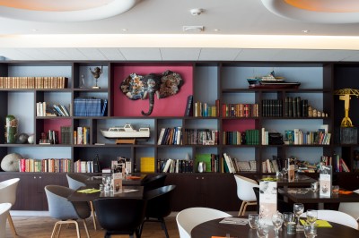 Salle de bain moderne avec baignoire, lavabo, miroir, peignoir suspendu et sol en damier noir et blanc.