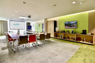 Salle de bain moderne avec baignoire, lavabo, miroir, peignoir suspendu et sol en damier noir et blanc.