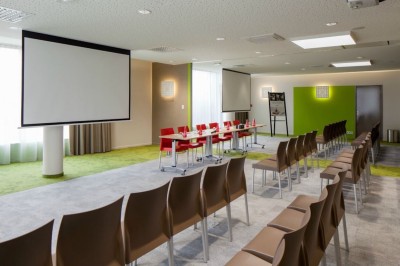 Salle de bain moderne avec baignoire, lavabo, miroir, peignoir suspendu et sol en damier noir et blanc.