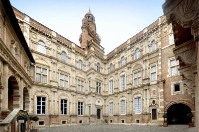 Miniature Location salle Toulouse (Haute-Garonne) - Ovyo #6 Cour intérieure d'un bâtiment historique en briques et pierre, avec une tour centrale et des fenêtres ornées.