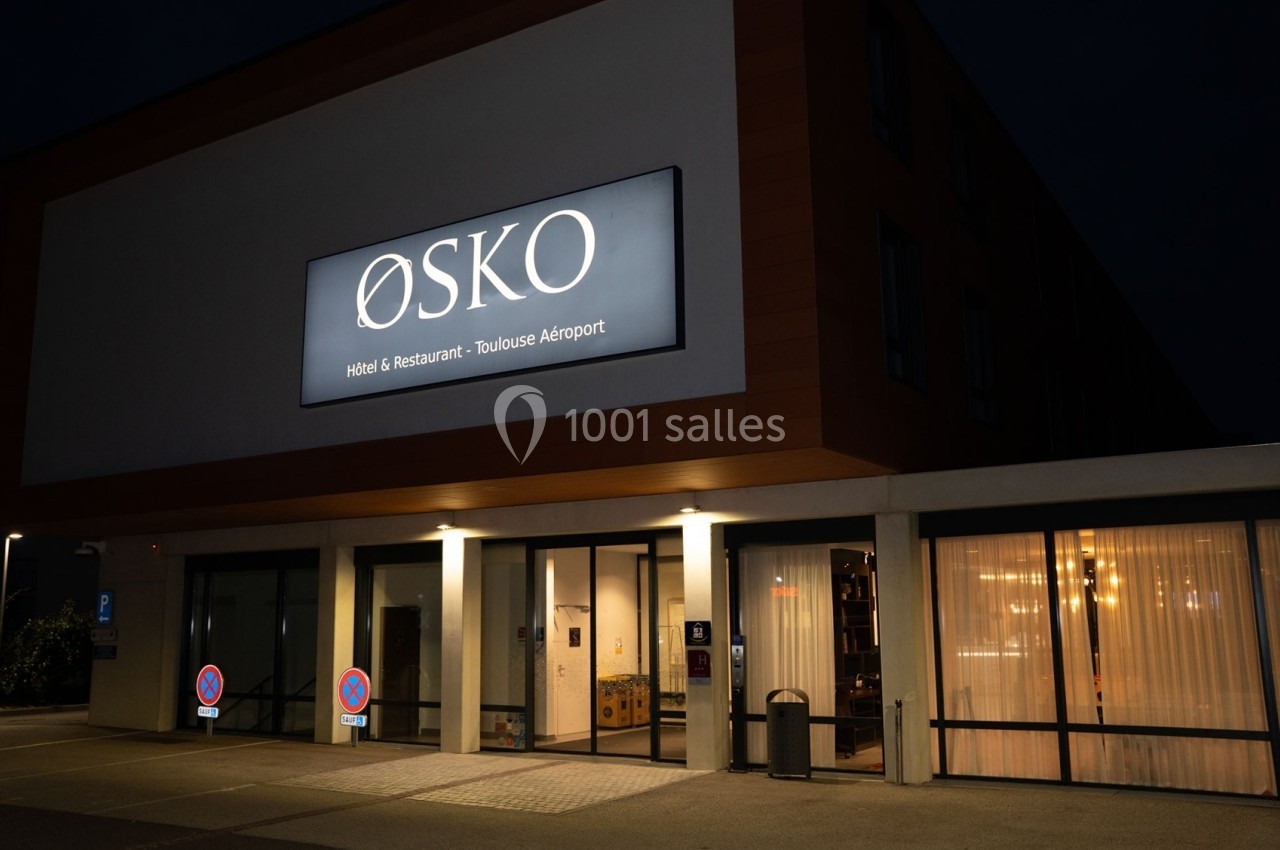 Façade éclairée de nuit d'un hôtel-restaurant avec le panneau ’ØSKO’ près de l'aéroport de Toulouse.