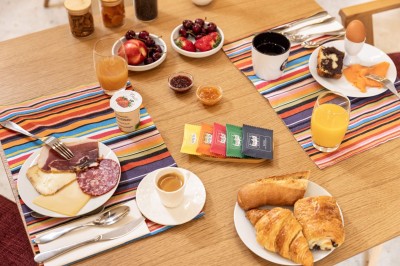 Salle moderne avec murs en briques apparentes, sol en bois et carrelage, écran mural et plante en pot.