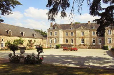 Chambre lumineuse avec lit, bureau en bois, chaise et mur décoré d'un papier peint à motifs végétaux.
