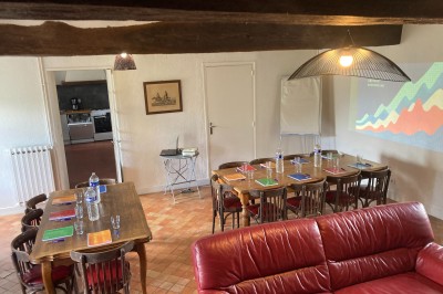 Chambre lumineuse avec lit, bureau en bois, chaise et mur décoré d'un papier peint à motifs végétaux.