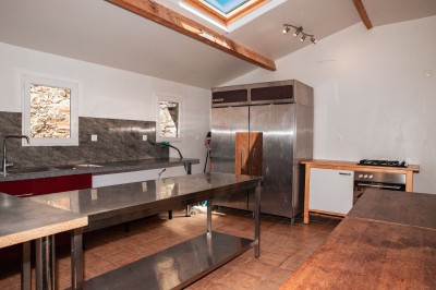 Chambre lumineuse avec lit, bureau en bois, chaise et mur décoré d'un papier peint à motifs végétaux.