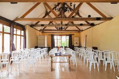 Chambre lumineuse avec lit, bureau en bois, chaise et mur décoré d'un papier peint à motifs végétaux.