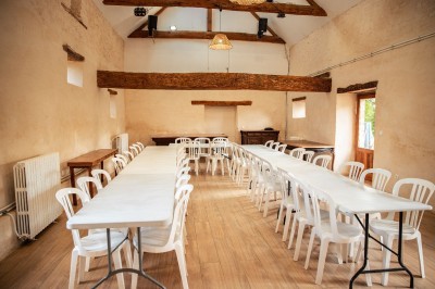 Chambre lumineuse avec lit, bureau en bois, chaise et mur décoré d'un papier peint à motifs végétaux.