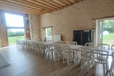 Chambre lumineuse avec lit, bureau en bois, chaise et mur décoré d'un papier peint à motifs végétaux.