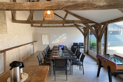 Chambre lumineuse avec lit, bureau en bois, chaise et mur décoré d'un papier peint à motifs végétaux.
