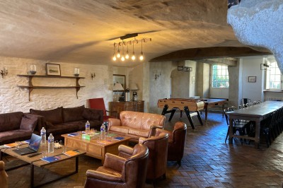 Chambre lumineuse avec lit, bureau en bois, chaise et mur décoré d'un papier peint à motifs végétaux.