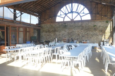 Chambre lumineuse avec lit, bureau en bois, chaise et mur décoré d'un papier peint à motifs végétaux.