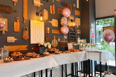 Salle chaleureuse avec parquet en bois, tables, chaises, canapés et éclairage tamisé.