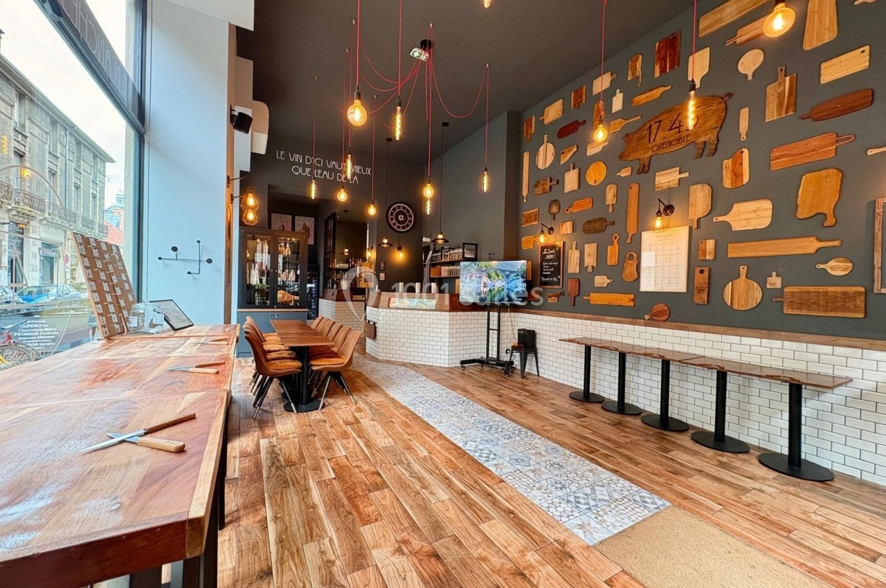 Intérieur d'un restaurant avec décoration murale de planches en bois, mobilier en bois et grandes baies vitrées.