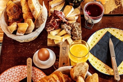 Dessert tiramisu en verrine avec une couche de cacao en poudre sur le dessus, posé sur une ardoise noire.