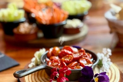 Dessert tiramisu en verrine avec une couche de cacao en poudre sur le dessus, posé sur une ardoise noire.