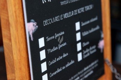 Dessert tiramisu en verrine avec une couche de cacao en poudre sur le dessus, posé sur une ardoise noire.