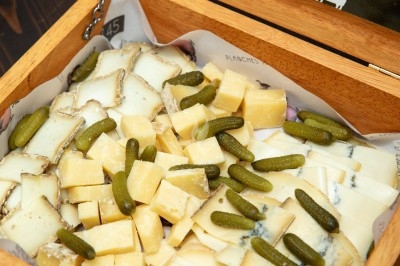 Dessert tiramisu en verrine avec une couche de cacao en poudre sur le dessus, posé sur une ardoise noire.