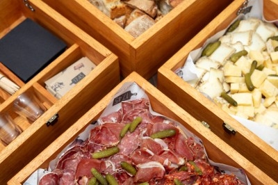 Dessert tiramisu en verrine avec une couche de cacao en poudre sur le dessus, posé sur une ardoise noire.