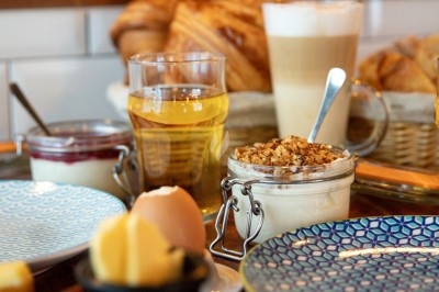 Dessert tiramisu en verrine avec une couche de cacao en poudre sur le dessus, posé sur une ardoise noire.