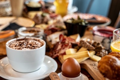 Dessert tiramisu en verrine avec une couche de cacao en poudre sur le dessus, posé sur une ardoise noire.
