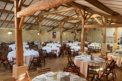 Miniature Location salle Le Bernard (Vendée) - La Grange du Prieuré #2 Centre de table avec des fleurs roses et blanches dans un vase doré, entouré de bougies et de verres sur une nappe blanche.