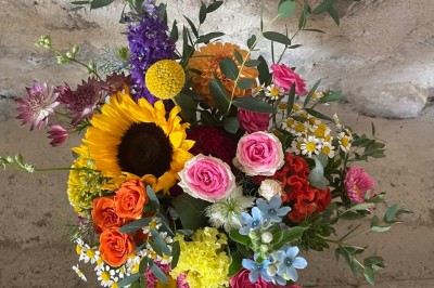 Miniature Location salle Le Bernard (Vendée) - La Grange du Prieuré #25 Centre de table avec des fleurs roses et blanches dans un vase doré, entouré de bougies et de verres sur une nappe blanche.