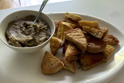 Assiette contenant un morceau de viande, des pommes de terre rôties et une portion de ratatouille.
