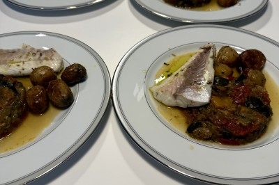 Assiette contenant un morceau de viande, des pommes de terre rôties et une portion de ratatouille.