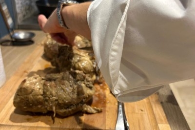 Assiette contenant un morceau de viande, des pommes de terre rôties et une portion de ratatouille.
