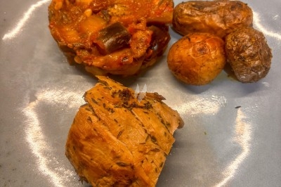 Assiette contenant un morceau de viande, des pommes de terre rôties et une portion de ratatouille.