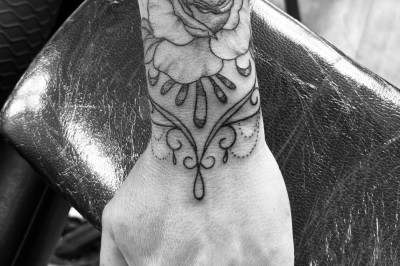 Tatouage sur une jambe représentant un papillon dont une aile se transforme en un bouquet de fleurs détaillées.