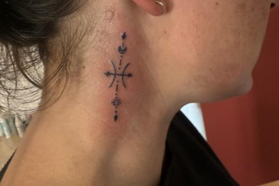 Tatouage sur une jambe représentant un papillon dont une aile se transforme en un bouquet de fleurs détaillées.