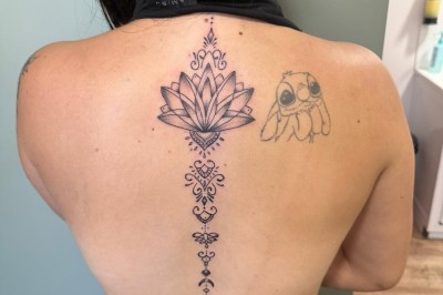Tatouage sur une jambe représentant un papillon dont une aile se transforme en un bouquet de fleurs détaillées.