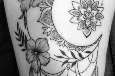 Tatouage sur une jambe représentant un papillon dont une aile se transforme en un bouquet de fleurs détaillées.