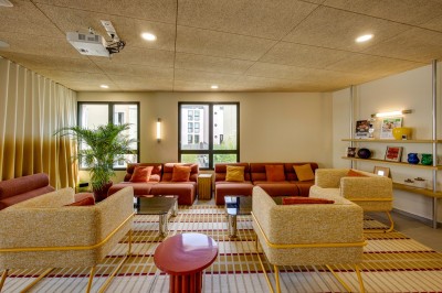 Salle de bain moderne avec douche à l'italienne, meuble en bois avec lavabo, miroir éclairé et serviettes pliées.