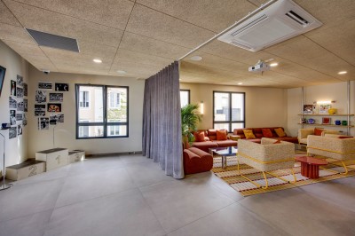 Salle de bain moderne avec douche à l'italienne, meuble en bois avec lavabo, miroir éclairé et serviettes pliées.