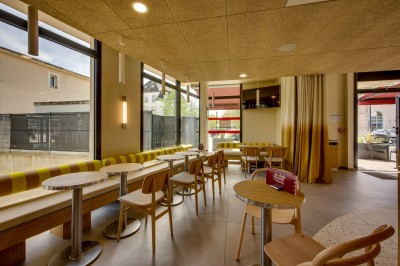 Salle de bain moderne avec douche à l'italienne, meuble en bois avec lavabo, miroir éclairé et serviettes pliées.