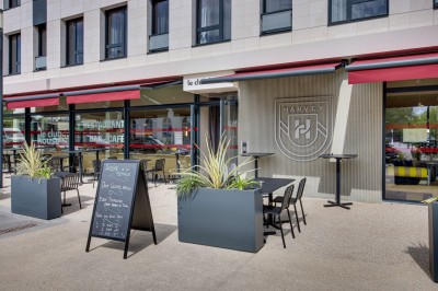 Salle de bain moderne avec douche à l'italienne, meuble en bois avec lavabo, miroir éclairé et serviettes pliées.