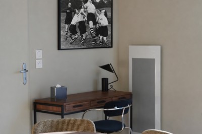 Salle de bain moderne avec douche à l'italienne, meuble en bois avec lavabo, miroir éclairé et serviettes pliées.
