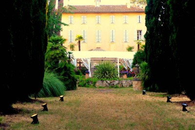 Miniature Location salle La Cadière-d'Azur (Var) - Château de Rochebelle - Var #4 Jardin verdoyant avec des pots en terre cuite et une tente blanche entourée d'arbres et de végétation.