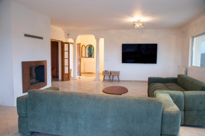 Miniature Location salle Adrets-de-l'Estérel (Var) - Domaine le Palais d’Azur #6 Cheminée moderne encastrée dans un mur blanc, avec une table basse en bois au premier plan et une porte vitrée à droite.