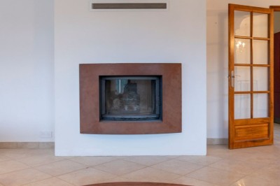 Miniature Location salle Adrets-de-l'Estérel (Var) - Domaine le Palais d’Azur #37 Cheminée moderne encastrée dans un mur blanc, avec une table basse en bois au premier plan et une porte vitrée à droite.