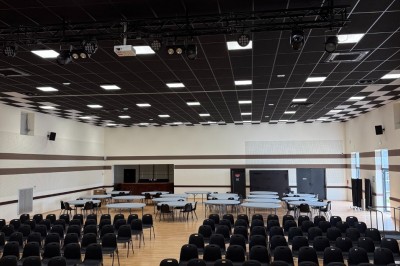 Miniature Location salle Erquy (Côtes-d'Armor) - Orion Evénement #3 Vue d'un espace de toilettes publiques avec cabines fermées, lavabos et miroir, sol en carrelage noir.