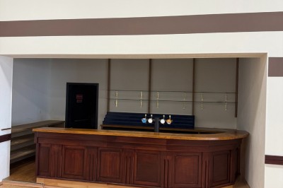 Miniature Location salle Erquy (Côtes-d'Armor) - Orion Evénement #5 Vue d'un espace de toilettes publiques avec cabines fermées, lavabos et miroir, sol en carrelage noir.