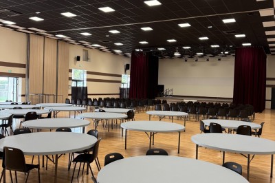 Miniature Location salle Erquy (Côtes-d'Armor) - Orion Evénement #4 Vue d'un espace de toilettes publiques avec cabines fermées, lavabos et miroir, sol en carrelage noir.